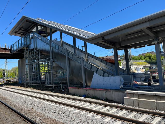 Neu eingebrachte Fahrtreppe unter dem Bahnsteigdach eines Bahnhofs