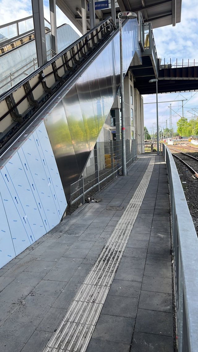 Fertig verkleidete Fahrtreppe entlang eines Bahnsteigs